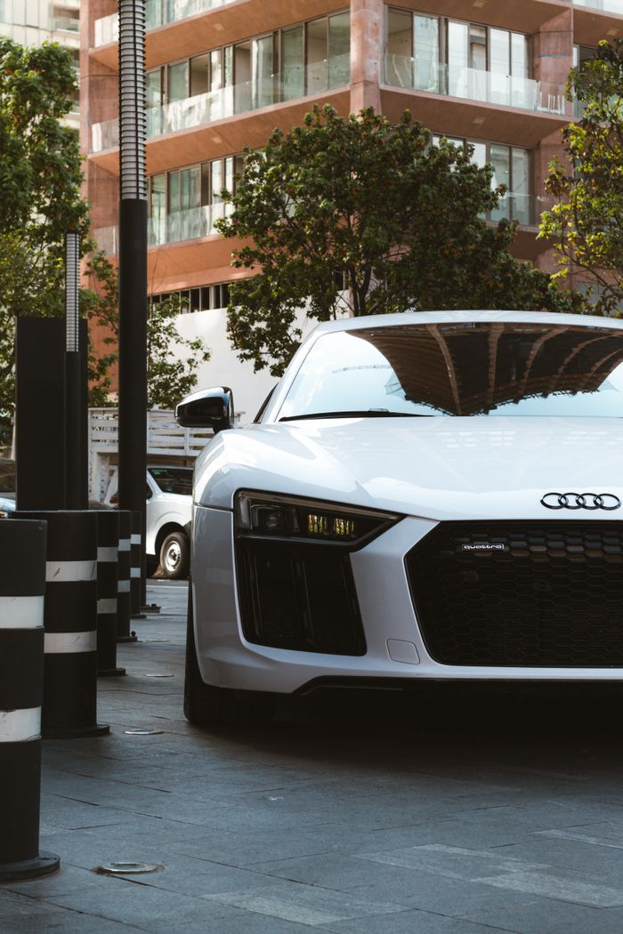 The Art of Drawing Readers In: Your attractive post title goes here White Audi R8 luxury car parked on a contemporary urban street, showcasing sleek design and elegance.