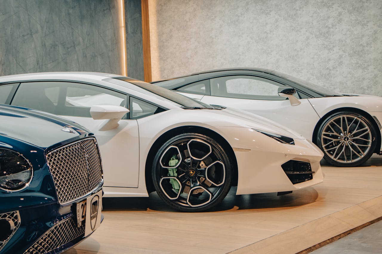 about-02 A lineup of sleek luxury sports cars on display in an upscale showroom setting.
