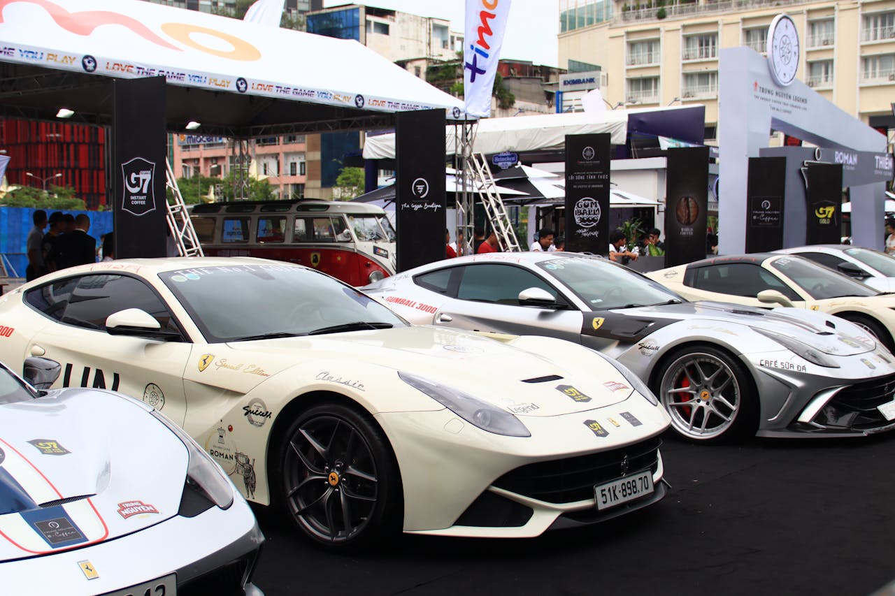 A collection of luxury sports cars showcased outdoors at a motor event.