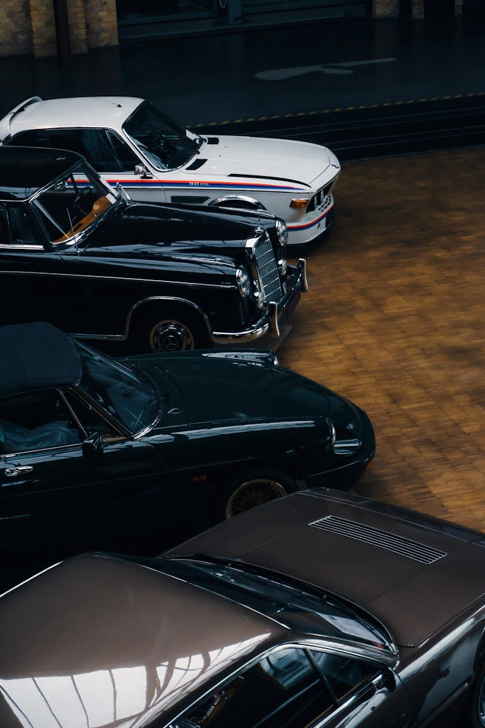 A collection of classic cars displayed indoors, showcasing vintage elegance.
