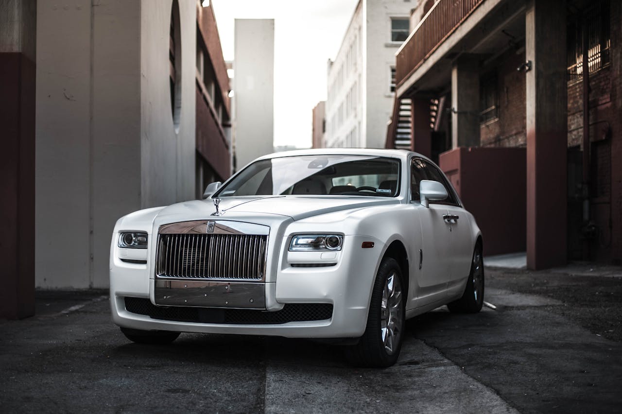 services-04 Elegant white luxury car parked in an urban alley, exuding sophistication and style.