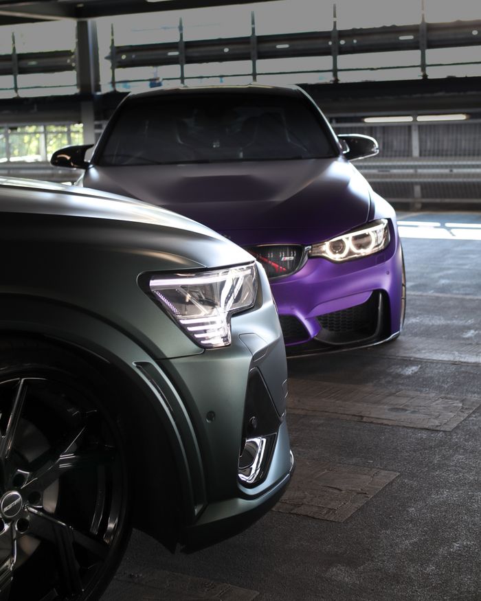 services-01 Close-up view of two luxury cars parked indoors, showcasing sleek design and elegance.